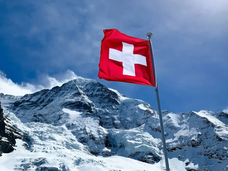 Red flag on top of snow covered mountain